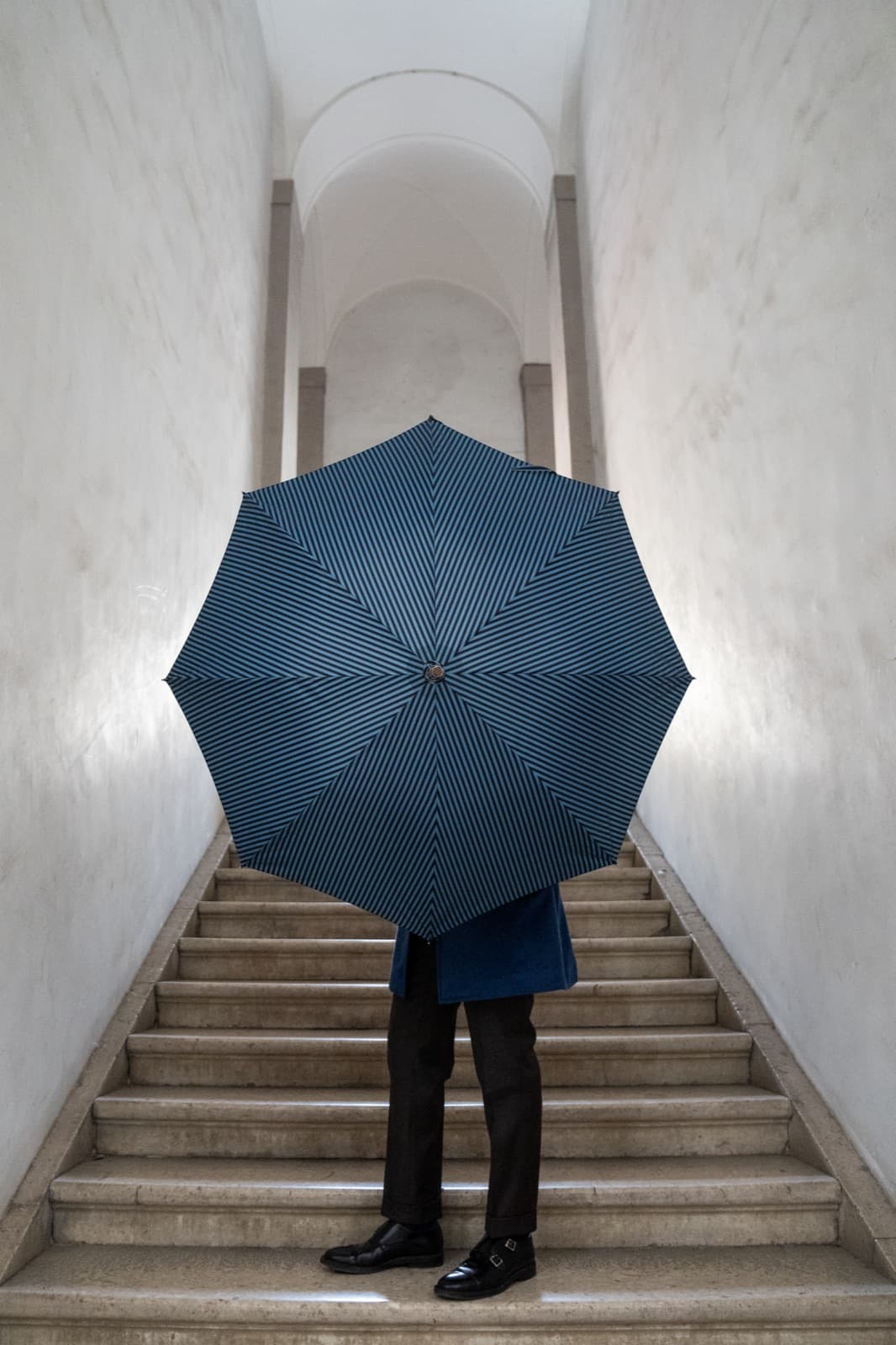 A gentleman ascending marble stairs: elegance that simply belongs.